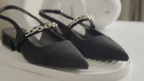 zapatos de gamuza negra con detalles de cadena de oro