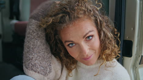 middle aged model posing on campervan stairs wearing cozy sweater close up.