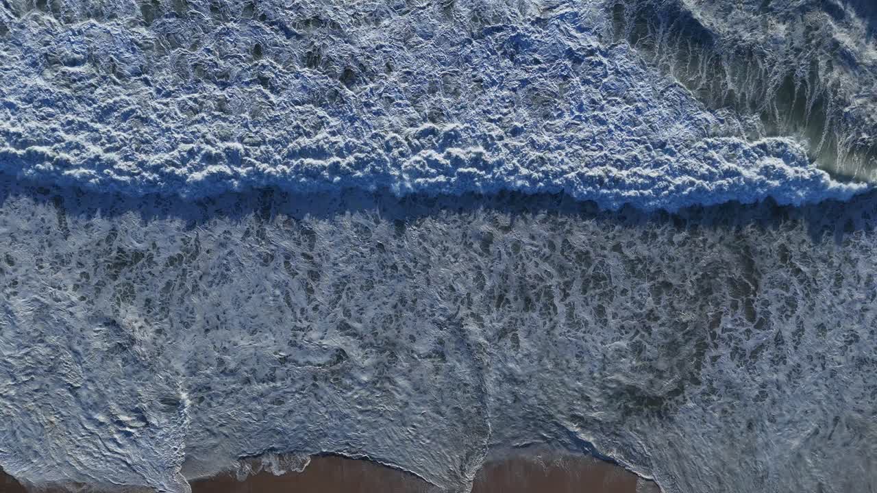 Big swell foam waters with white water waves in slow motion at 100 fps