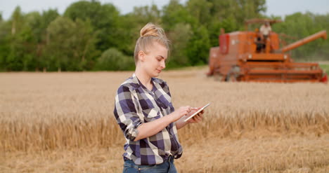 agricultora agrícola usando tableta digital en la cosecha