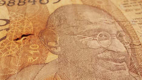 captivating closeup shots of various currency bills featuring mahatma gandhi, including rupees and dollars. unique onedollar bill with a hole. money handling and currency art captured in detail
