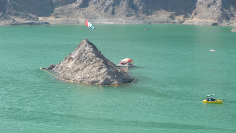 toma estática de la bandera de los emiratos árabes unidos y el barco recreativo en el lago de la presa de hatta