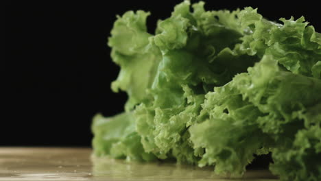 cámara lenta de lechuga cayendo en una tabla de cortar