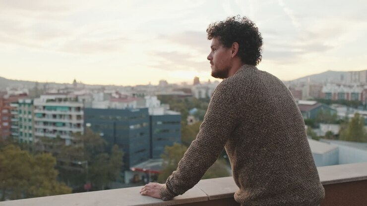 Uomo che guarda una città da un tetto