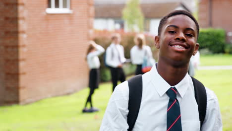 portrait of  male teenage student in uniform outside school