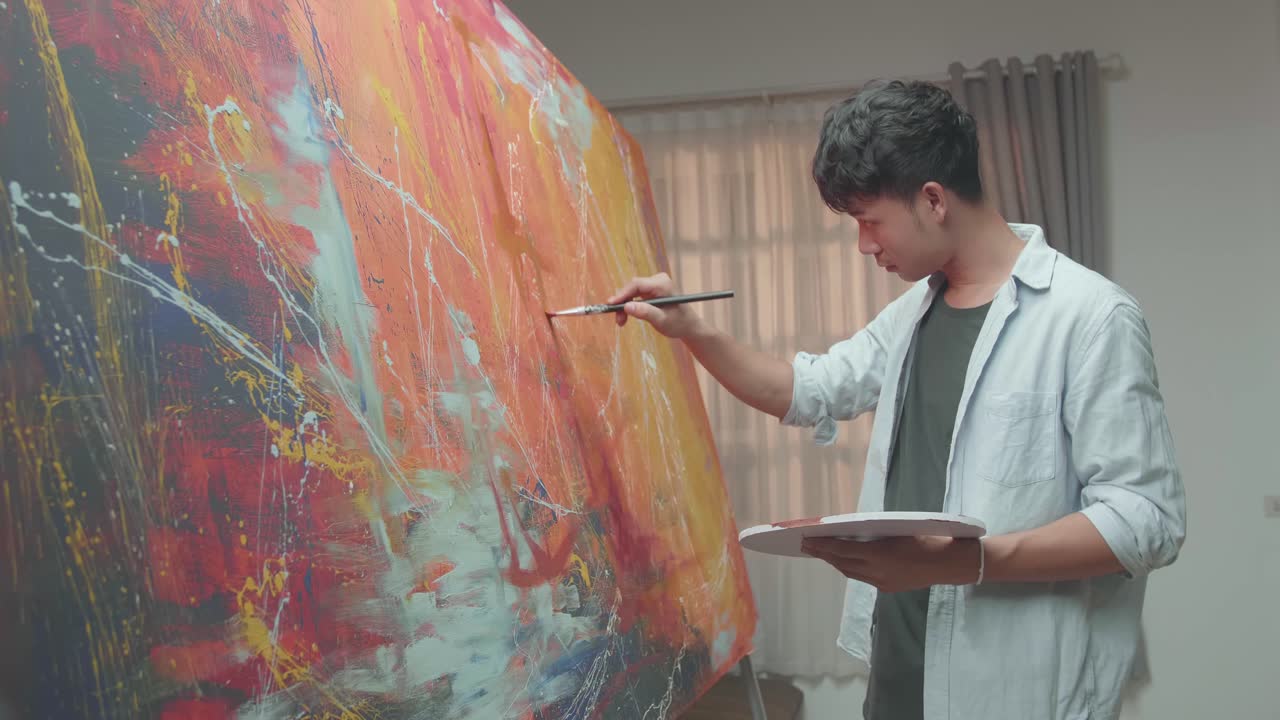 Asian Man Working On Abstract Painting