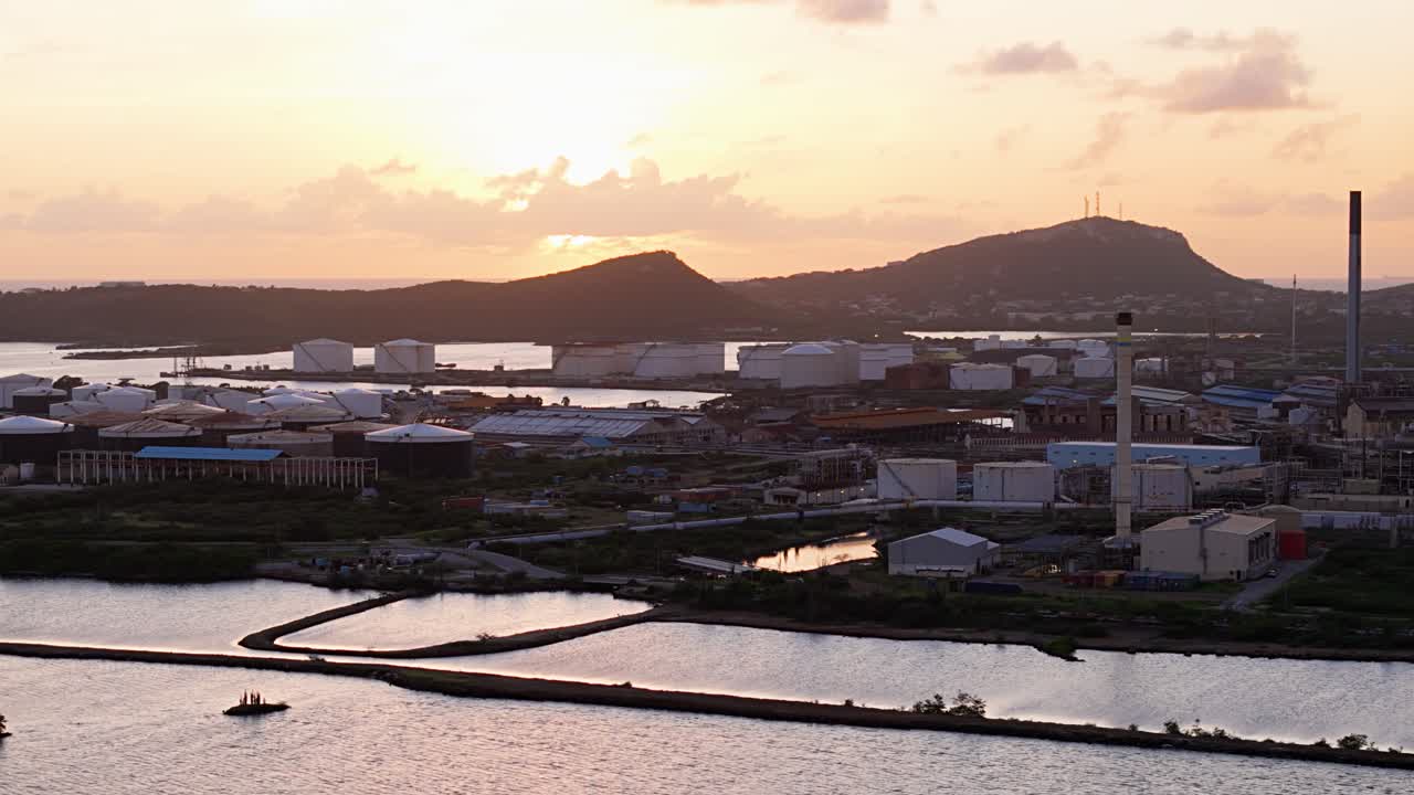 섬에 있는 석유 정유소의 플레어 스택과 함께 산업 구역을 둘러싼 왼쪽에서 오른쪽의 드론