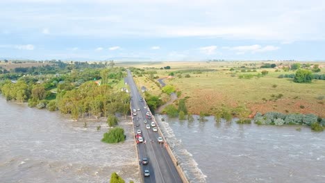 strong river flowing under low lying bridge, vaal dam south africa, drone shot of vaal river