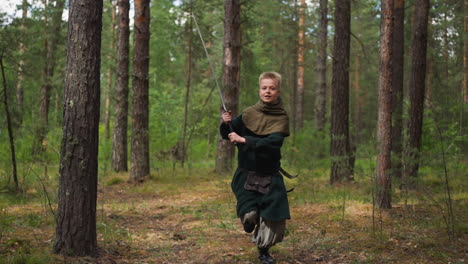 joyful boy in medieval costume sword runs training in wood