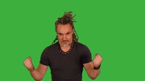 martial artist doing fighting training isolated on green screen background. energetic mid age rasta man boxing against camera.