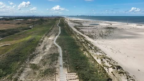 Flight-along-lush-green-Kijkduin-dunes-and-artificial-Zandmotor-beach