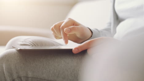 manos de una mujer usando una computadora tablet comprando en línea en casa