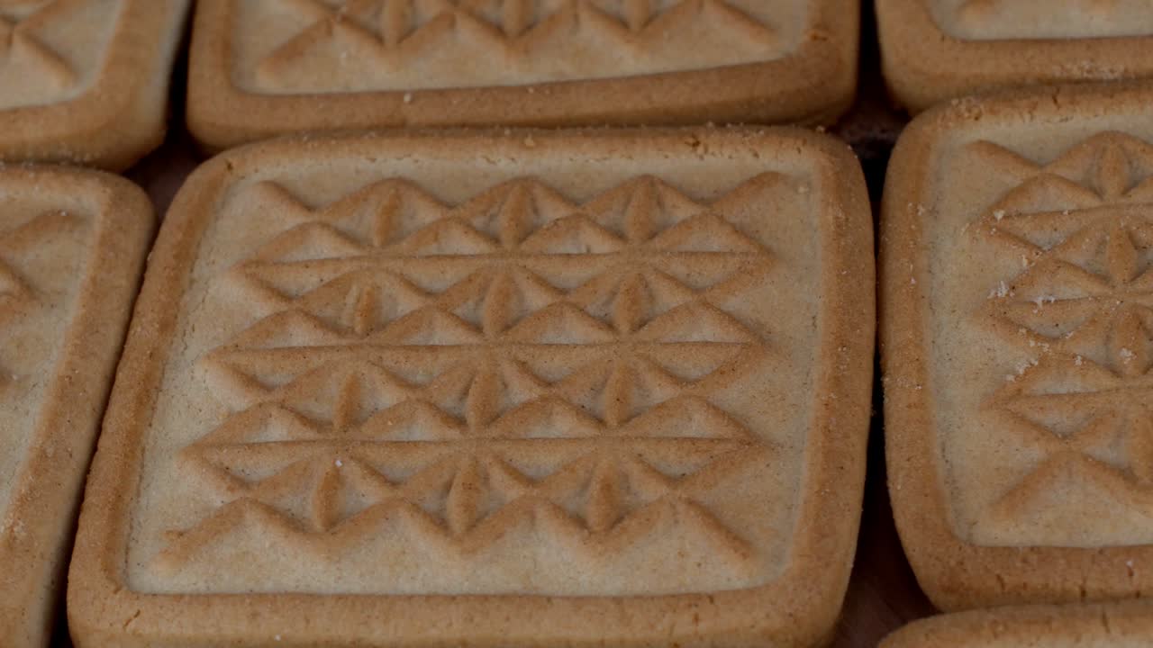 Square crispy butter cookies detailed textured surface rotation.