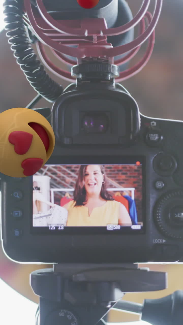 animación de iconos emoji sobre vlogger femenino en el visor de la cámara grabando vlog en casa