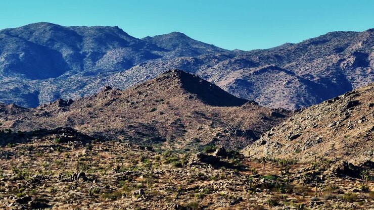 A drone shot panning left from right of a mountain in the high desert of California