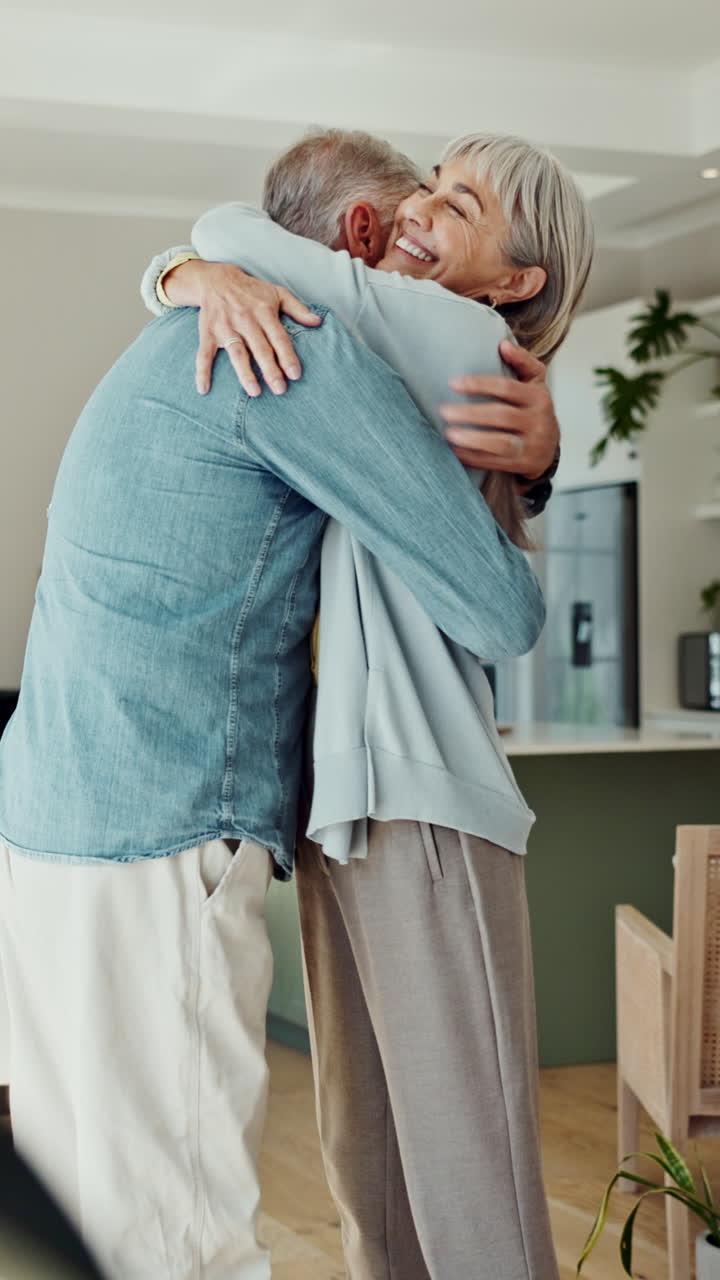 Pareja de ancianos feliz bailando y abrazándose cariñosamente en casa.