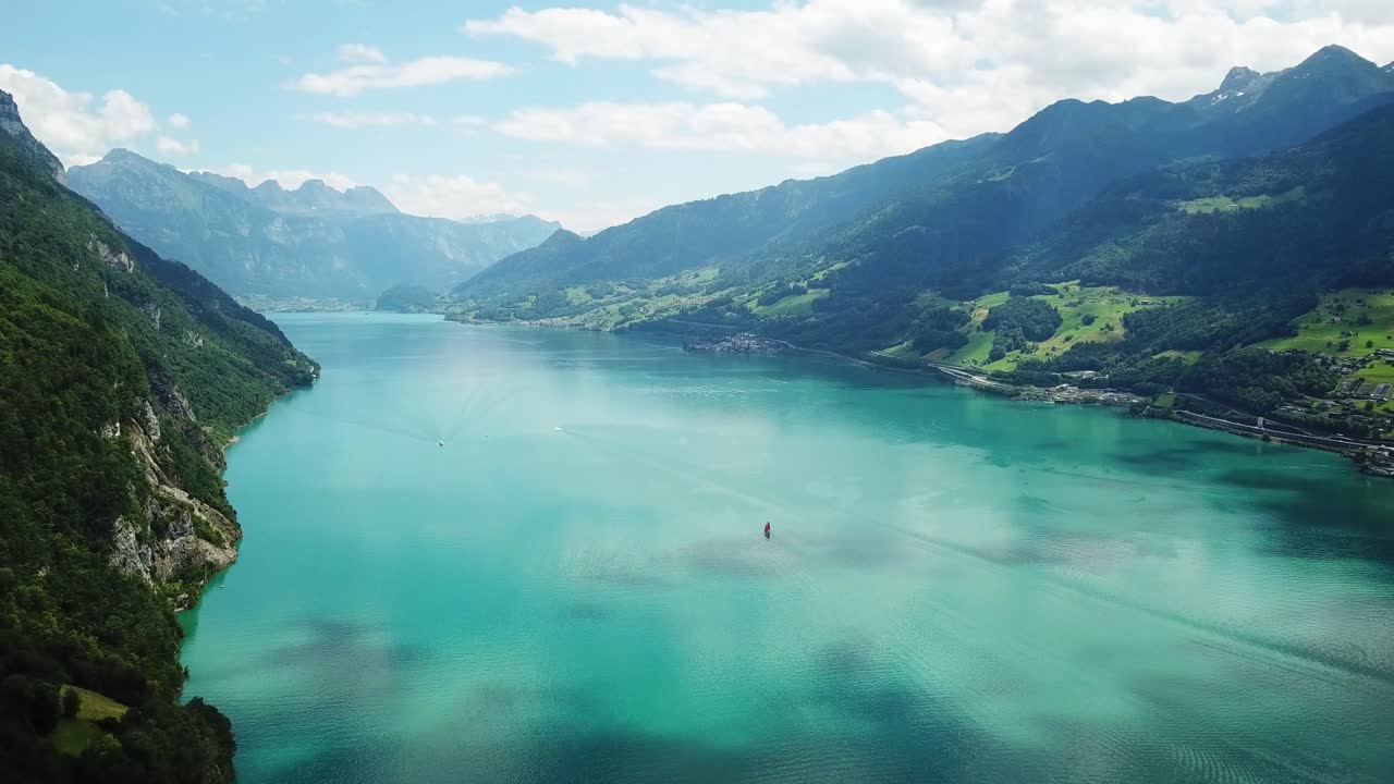 a sailboat gliding on Lake Walen (Walensee) turquoise waters in eastern Switzerland ,the world-famous Heidiland for heidilandHeidi story, Walensee, Switzerland