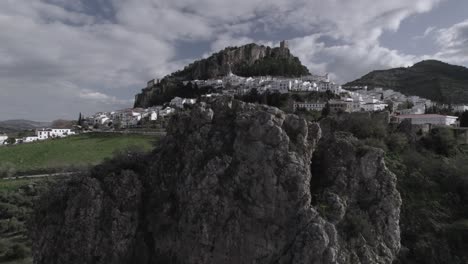 ascending crane shot in 4k of zahara de la sierra, spain, filmed with a dji drone at 30fps. a cinematic reveal of the picturesque village with its historic castle in the background.
