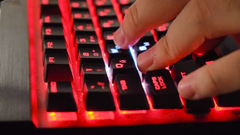 person typing on a red led gaming keyboard