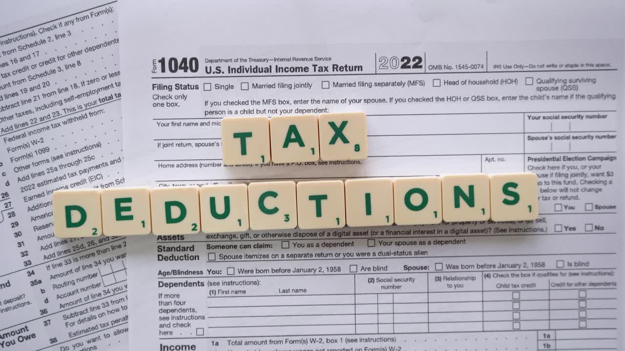 Phrase "tax deductions" with green letters over a US tax form