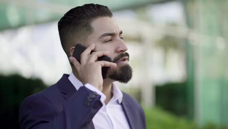 hombre de negocios hablando por teléfono celular y mirando hacia afuera