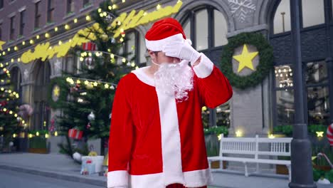 papá noel asiático con dolor de cabeza mientras está de pie en la noche de navidad