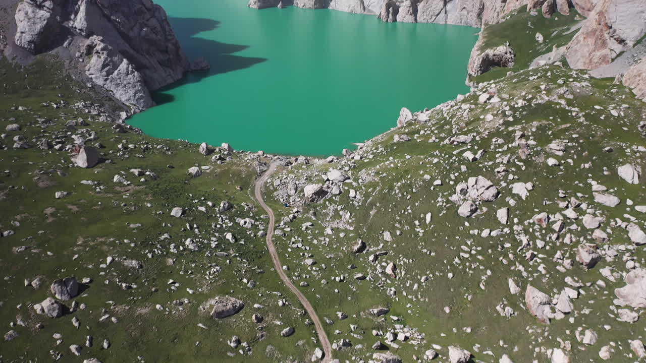 Epica ripresa aerea cinematografica che parte da un sentiero e rivela il lago Kel-Suu in Kirghizistan