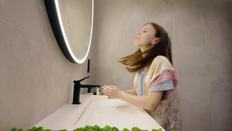 girl washing hands in a modern bathroom