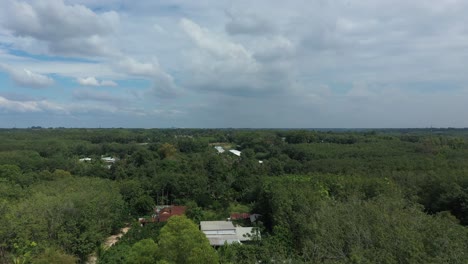 Aerial-crane-shot-of-Cu-Chi,-Vietnam-with-farms,-forests-on-sunny-day-with-blue-sky