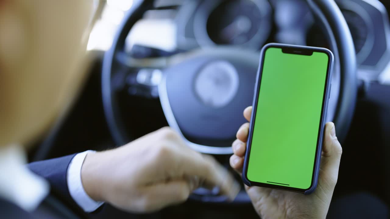 hombre con la mano usando un teléfono móvil chromakey con pantalla verde vacía en un coche moderno. maqueta de pantalla táctil. búsqueda en internet. desplazamiento de pantalla de teléfono inteligente de primer plano