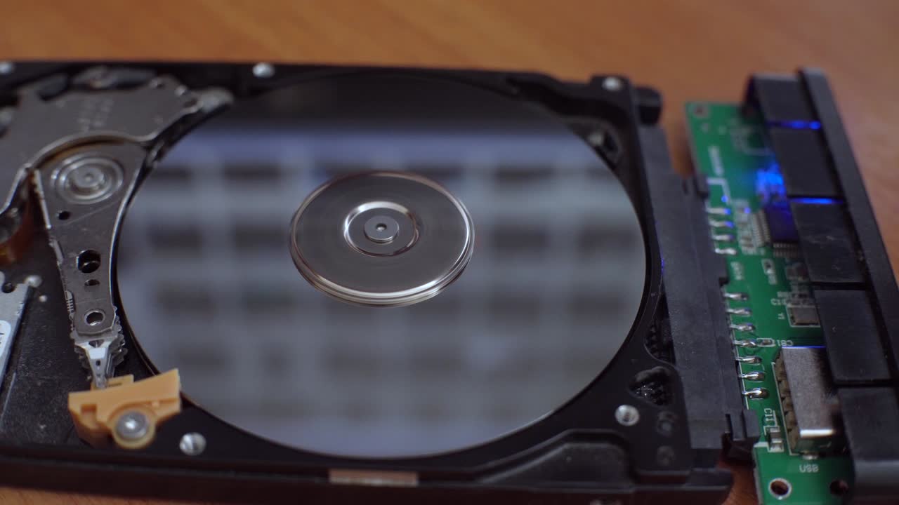 하드 디스크는 테이블 위에 놓여 있으며, 박이고 회전하는 디스크입니다.