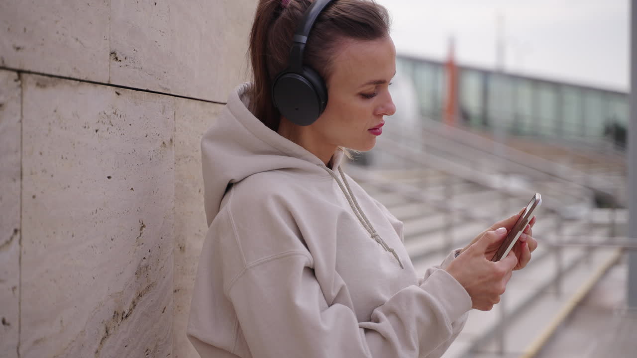 mujer usando el teléfono y escuchando música al aire libre