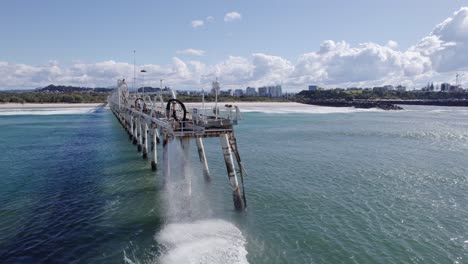 sand-water mixture being pumped out from tweed river entrance through sand bypassing facility on tsb jetty in australia