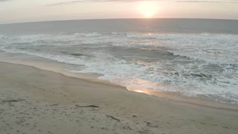 A-tilt-reveal-of-the-sunset-with-the-beach-as-the-first-view