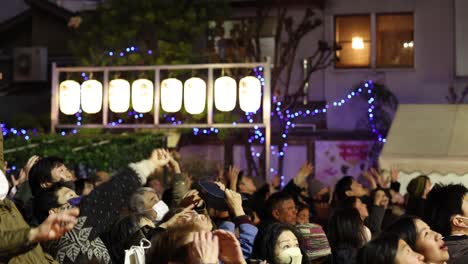 people cheering at an outdoor evening gathering