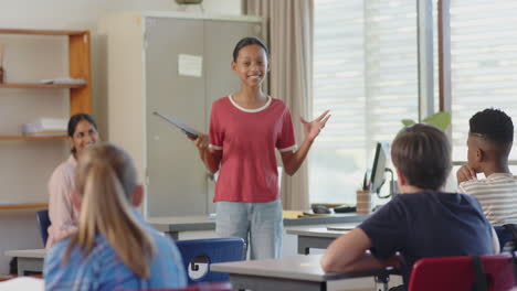 in school, girl presenting with tablet in classroom, engaging with classmates