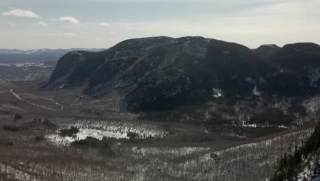 mountainous dome during hazy morning with freezing lake in middle at mont du dome in quebec, canada