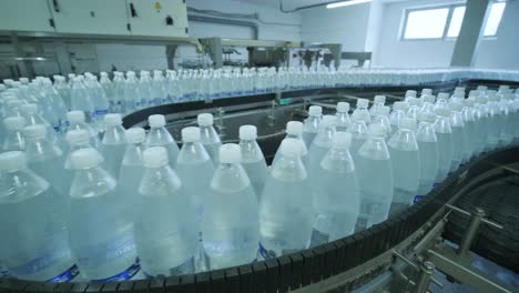 cinta transportadora con botellas de agua potable en una planta de bebidas moderna