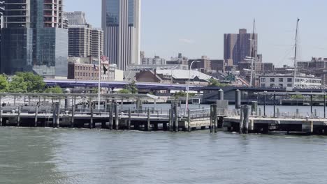 Eine-Statische-Aufnahme-Der-Skyline-Des-Finanzviertels-Im-Stadtzentrum-Von-New-York-Mit-Der-Brooklyn-Bridge-Am-East-River