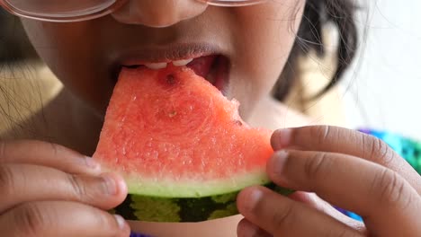 close-up of a child eating a slice of watermelon