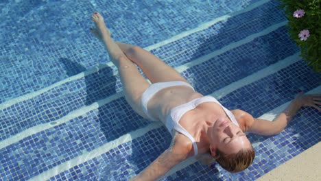 relaxed young lady enjoying summer day while sunbathing pool