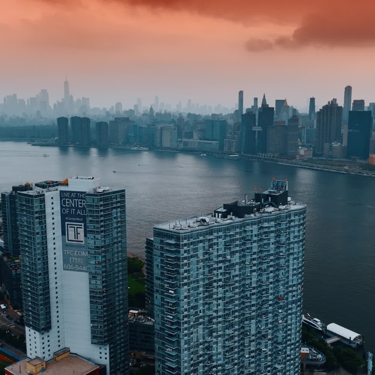Pink cloudy sky above amazing New York. Drone footage rising along the skyscrapers standing on the waterfront