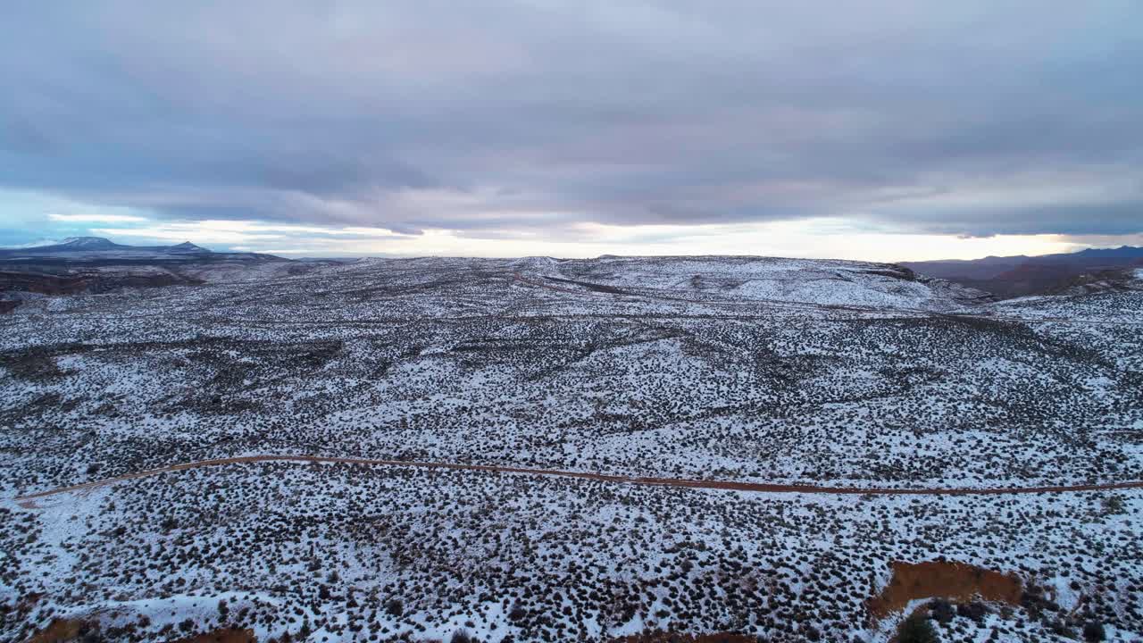 Droneopptak over den snødekte ørkenen på en overskyet dag i Utah.