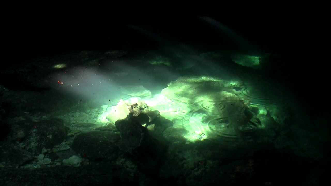 piscinas verdes brillan a la luz del sol en el fondo de una cueva