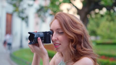 red-haired woman taking photos in a park