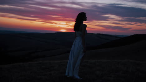woman in a dress at sunset over the hills