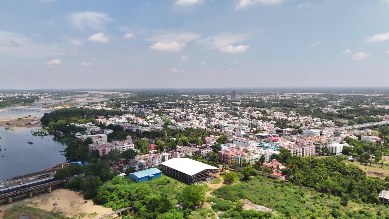 Vista aerea cinematografica del Tempio di Sri Ranganathaswamy che si erge sopra la storica città tempio. Densi quartieri residenziali, lussureggianti piantagioni di cocco e il lontano fiume Kaveri creano uno scenario culturale mozzafiato.