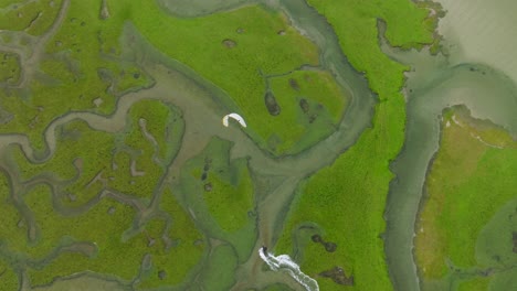 Amplia-Vista-Aérea-De-Un-Aventurero-De-Kitesurf-Navegando-A-Través-De-Un-Delta-De-Un-Río-Verde-Brillante-En-La-Isla-De-Achill-En-Irlanda