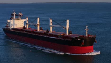 aerial view of the red tomini unity ship sailing on the sea at sunset