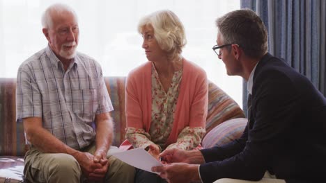 senior couple talking with a business man in retirement house